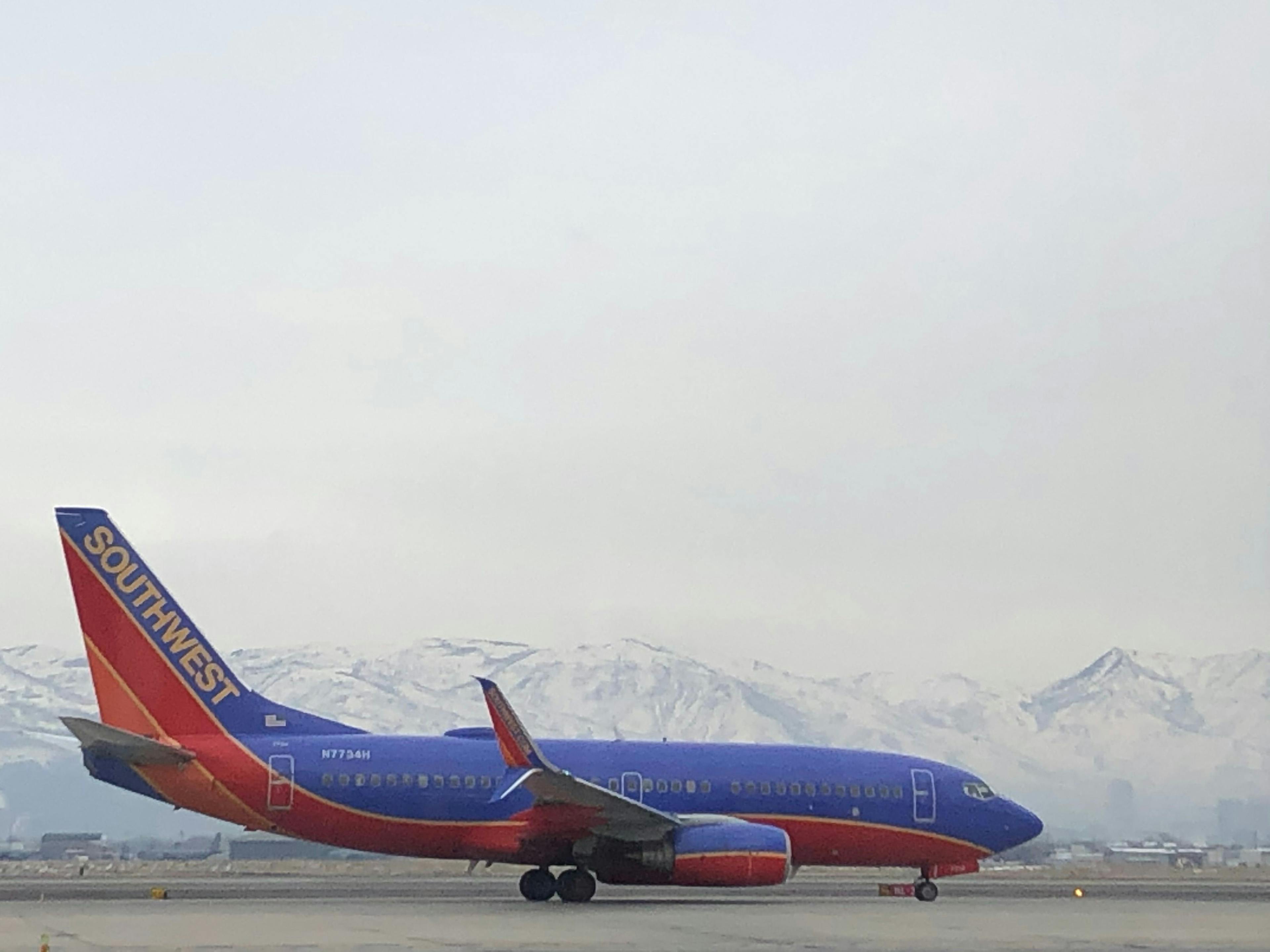 A Southwest plane next to the snow covered mountains.