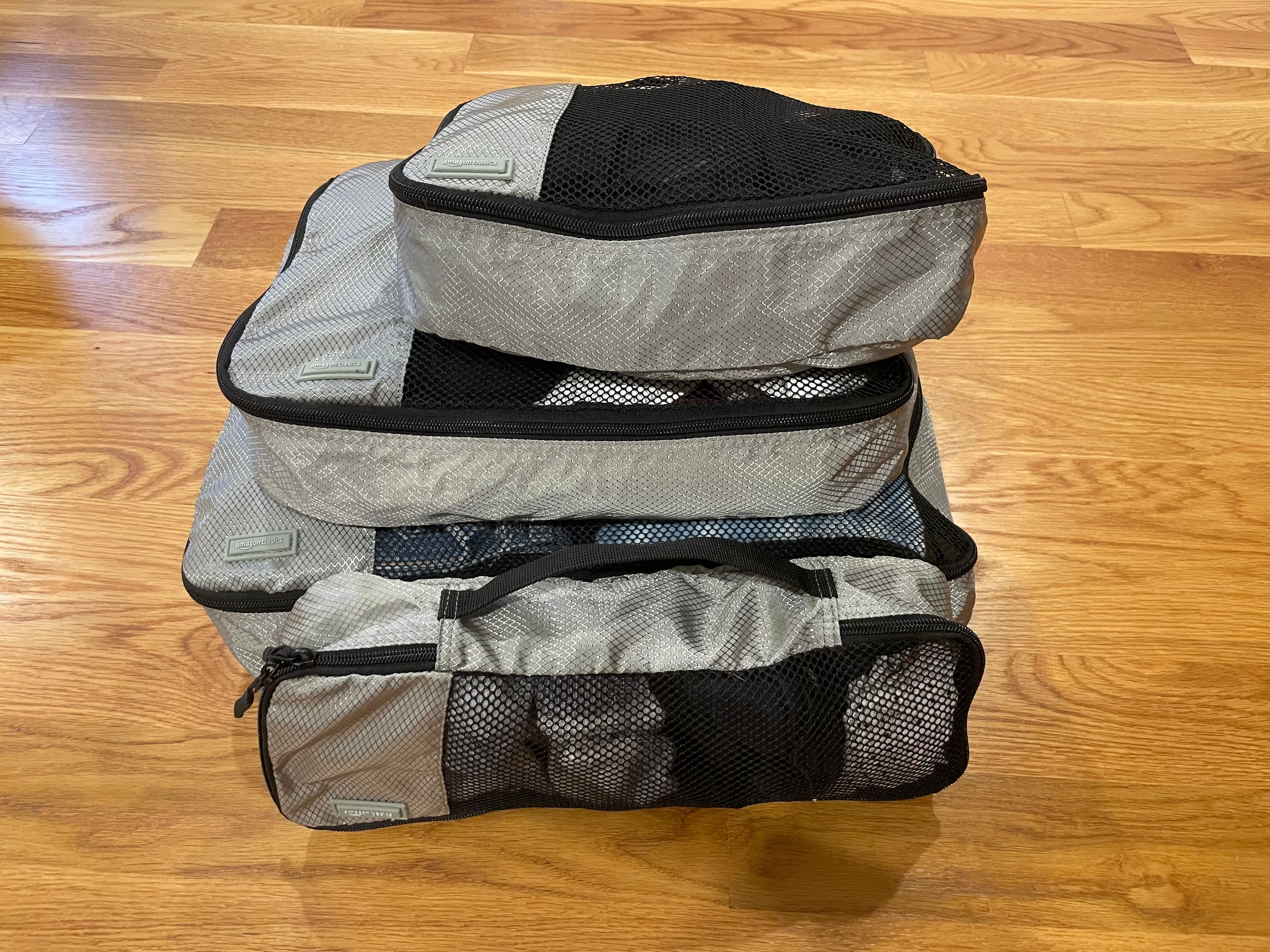 Three gray packing cubes stacked on top of each other, with another one in front.