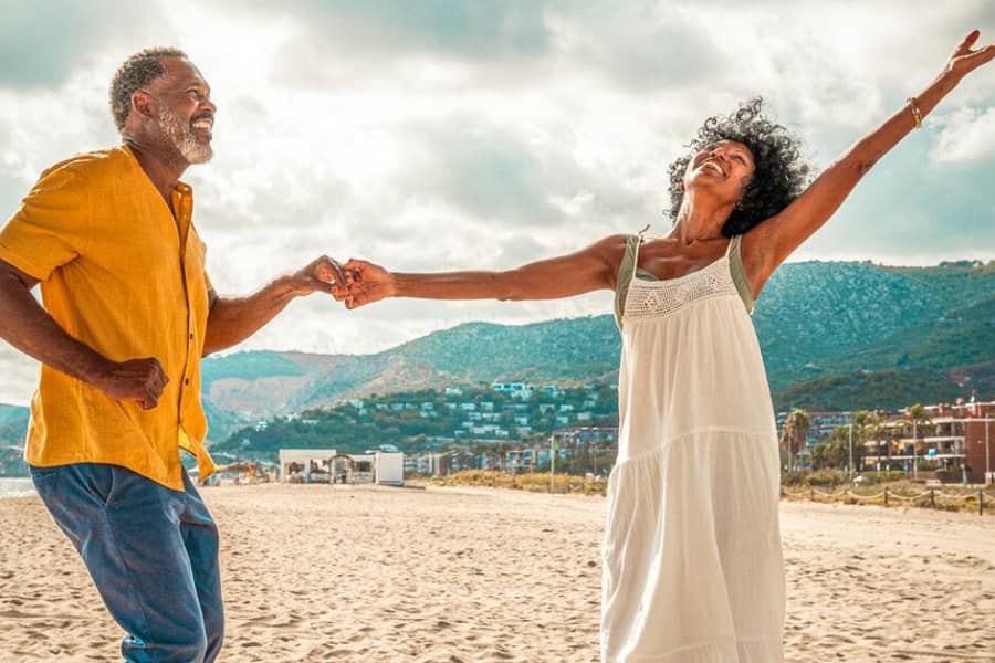 A couple dances and smiles on a vacant beach