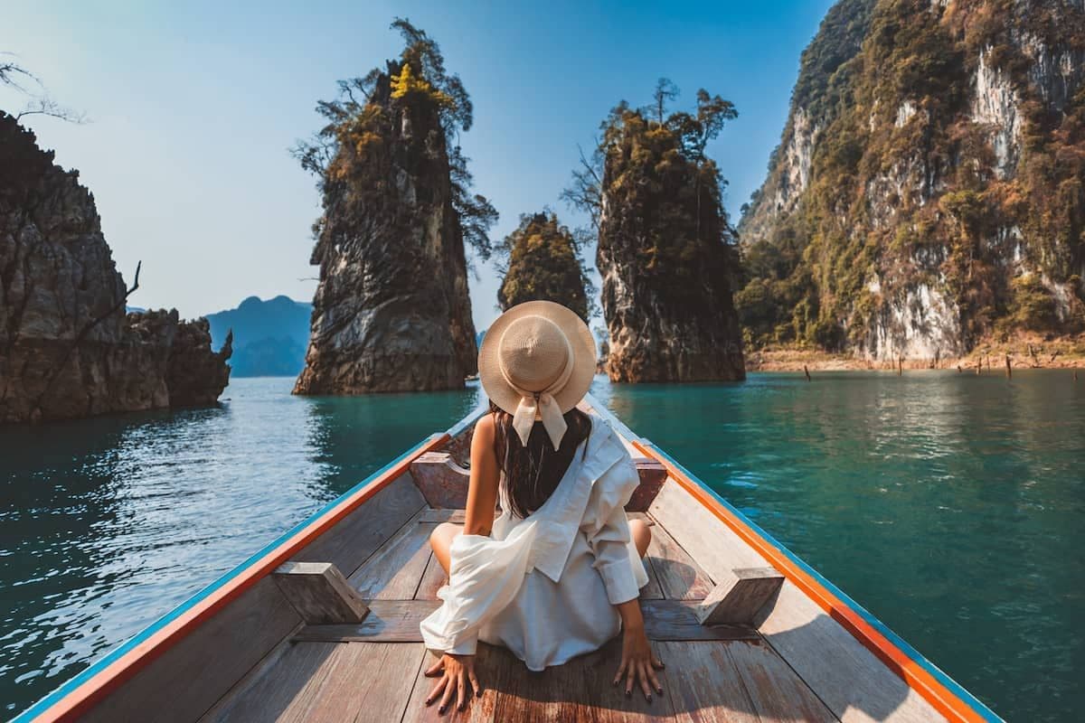 A woman on a longtail boat on the water in Thailand.