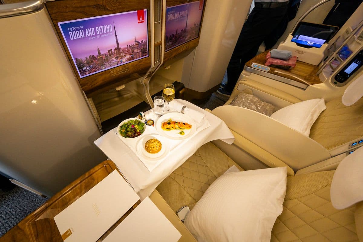 Emirates business class seat with a meal service tray and seatback screen