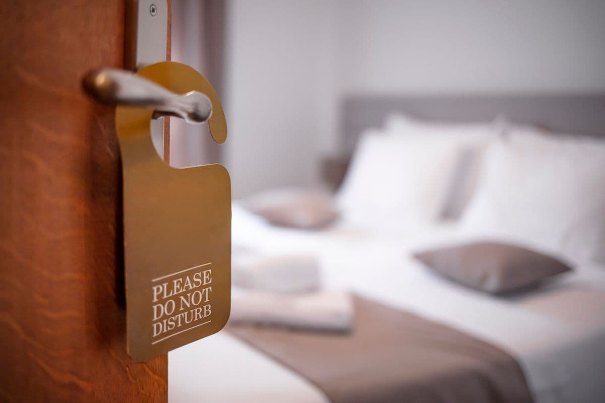 A "do not disturb" sign hanging on a hotel room doorknob.