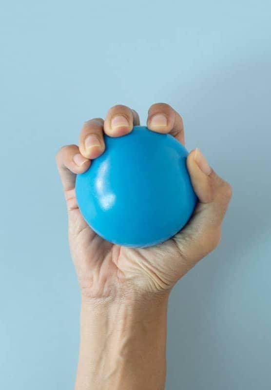 A hand grasps a blue stress ball