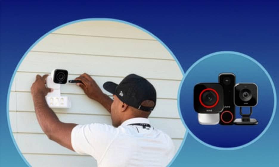 Person installing a wireless home security camera on the exterior wall of a house.