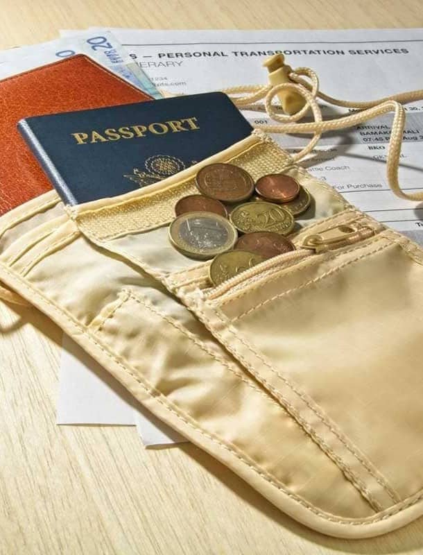 A money belt holding a passport, coins, and a slim wallet