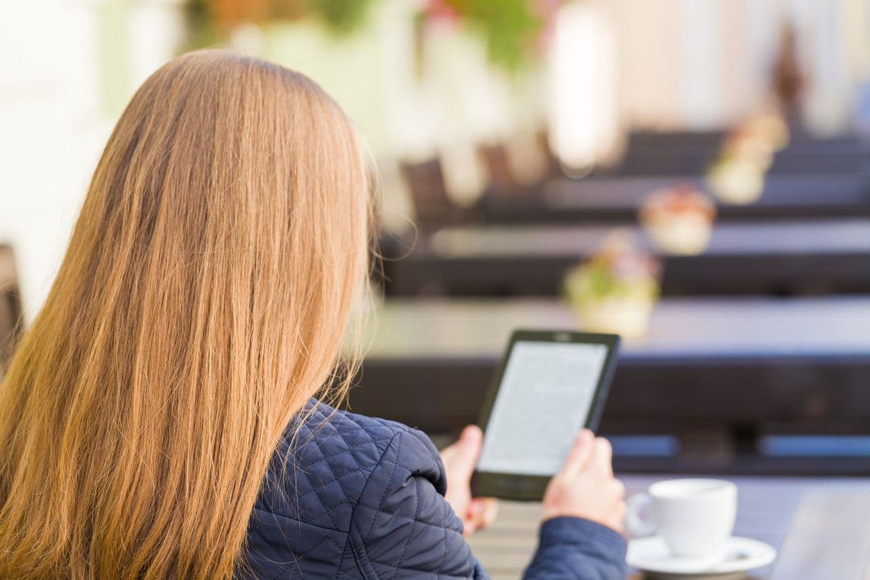 A woman holds an Amazon Kindle