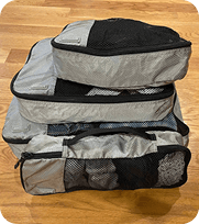 Several gray Amazon Basics packing cubes stacked on top of each other