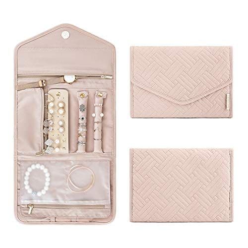A foldable travel jewelry case in blush pink, shown open with rings, earrings, and bracelets inside
