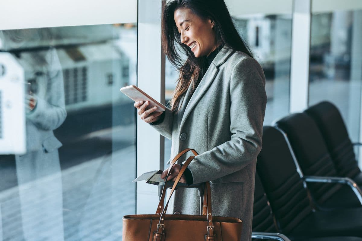 A woman checks her phone while at the airport.